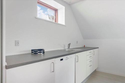 a white kitchen with a sink and a window at 6797-Allinge-Nordre-Strandvej-127 in Allinge