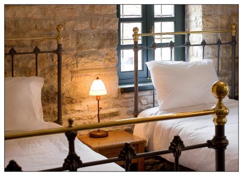 a bedroom with two beds and a lamp on a table at Gaia Guesthouse in Dilofo