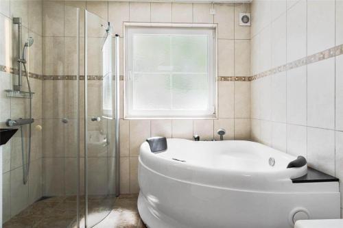 a bathroom with a tub and a glass shower at 3627-Nexo-Sandstien-5 in Neksø