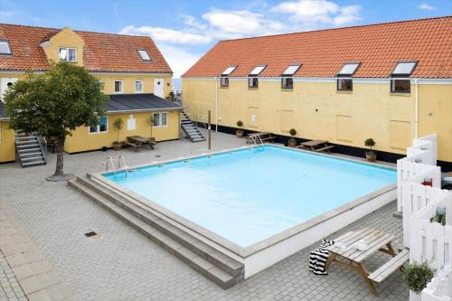 a large swimming pool in a courtyard with buildings at 5645-Gudhjem-Broddegade-14-lejl-13 in Gudhjem