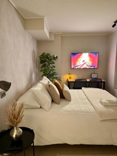 a bedroom with a white bed with a tv on the wall at Hermoso Apartamento a pasos de Santa Lucía in El Cerrillo