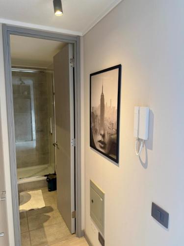 a bathroom with a picture of a city on the wall at Hermoso Apartamento a pasos de Santa Lucía in El Cerrillo