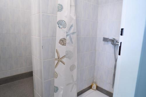 a shower with a shower curtain with seashells at Penzión Oliver Humenné in Humenné