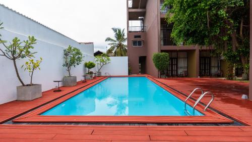 a swimming pool in front of a building at Waves Hostel in Negombo