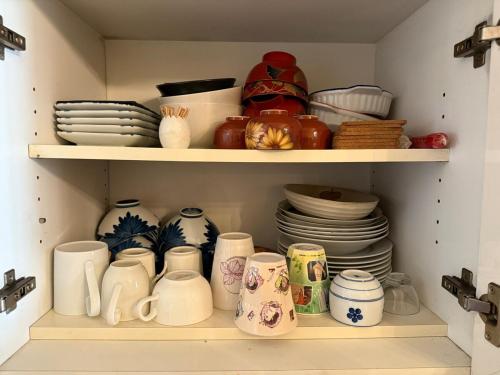 a cupboard filled with lots of dishes and plates at Ikko's House in Ito