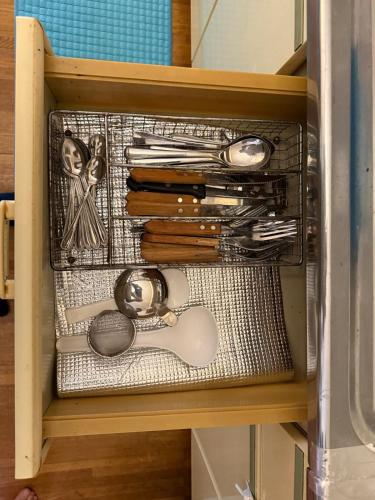 a drawer full of utensils in a cabinet at Ikko's House in Ito