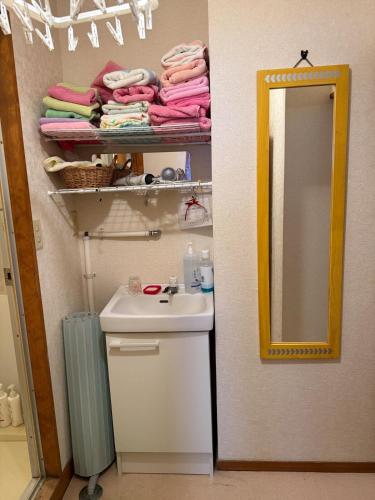 a bathroom with a sink and a mirror and towels at Ikko's House in Ito
