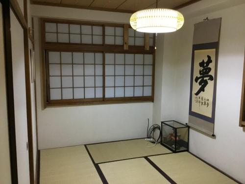 an empty room with a window and a table in a room at Ikko's House in Ito