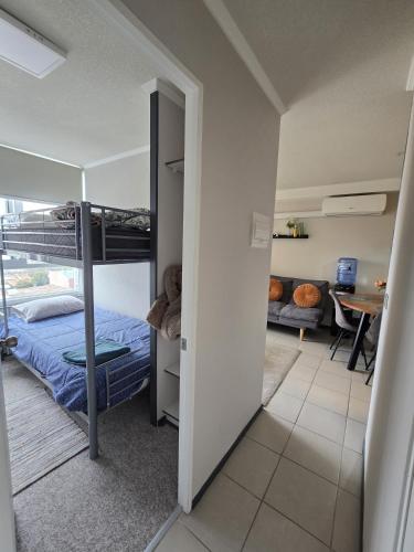 a bedroom with a bunk bed and a living room at Céntrico dep 2 habitaciones 1 baño in Rancagua
