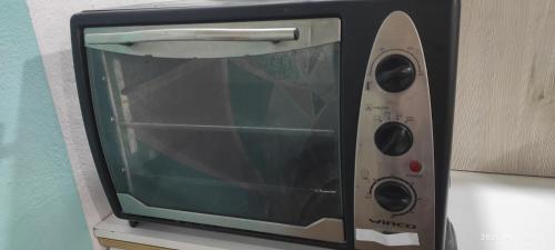 a microwave oven sitting on top of a counter at Ezeiza 3 departamento privado a 15 minutos del aeropuerto hasta 7 personas OPCIONAL TRANFER DESDE Y HACIA EL AEROPUERTO DE EZEIZA LAS 24 HORAS pet friendly conexion con Aeroparque in Ezeiza