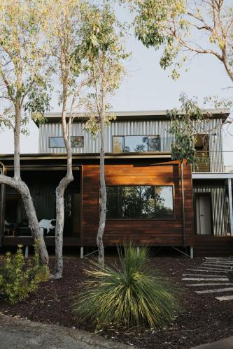 a house with a wooden facade with trees at Palmiera Escape - Luxury, laid-back holiday home in Margaret River in Margaret River Town