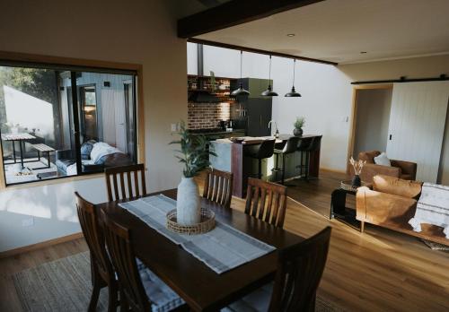 a dining room and living room with a table and chairs at Palmiera Escape - Luxury, laid-back holiday home in Margaret River in Margaret River Town