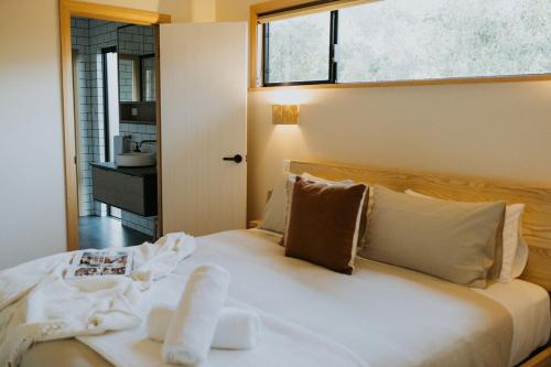 a bedroom with a large white bed with a window at Palmiera Escape - Luxury, laid-back holiday home in Margaret River in Margaret River Town