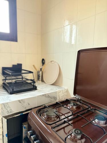 a kitchen with a stove top in a kitchen at Satya in Motsouémbé