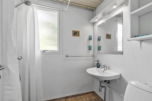 a white bathroom with a sink and a shower at 5506-Gudhjem-Gudhjemvej-111-N in Gudhjem