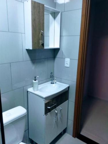 a bathroom with a sink and a toilet and a mirror at Pousada Santa Maria in Canoinhas