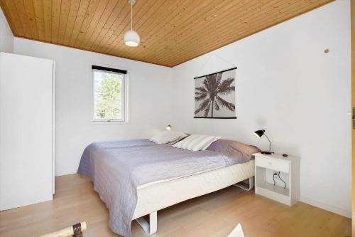 een slaapkamer met een bed en een houten plafond bij 1502-Aakirkeby-Malurtvej-7 in Vester Sømarken