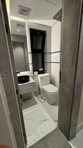 a bathroom with a toilet and a sink at The coze spot in Ath Thuqbah