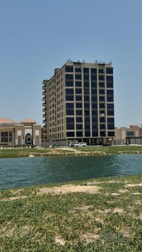 a tall building in front of a body of water at The coze spot in Ath Thuqbah