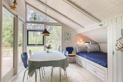 ein Esszimmer mit einem Tisch und einem Bett in der Unterkunft 2681 Nexø - Munkegårdsskoven 26 in Neksø