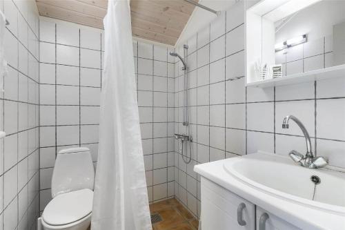 ein weißes Badezimmer mit Toilette und Waschbecken in der Unterkunft 2681 Nexø - Munkegårdsskoven 26 in Neksø