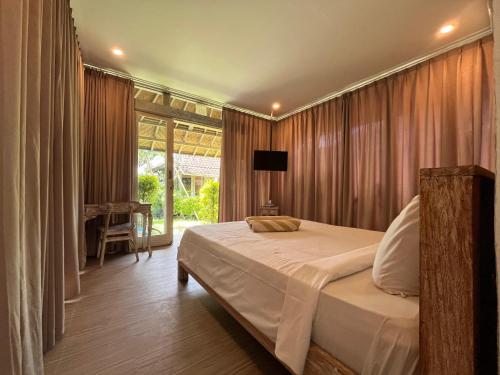 a bedroom with a bed and a television in it at Villa Alisha in Canggu