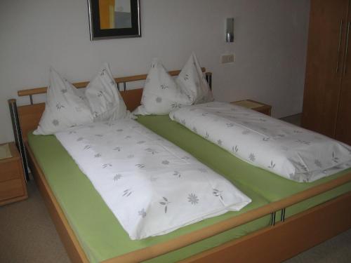 duas camas com lençóis brancos e pássaros nelas em Gästehaus Renate em Biberwier