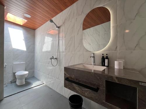 a bathroom with a sink and a toilet and a mirror at Villa Alisha in Canggu