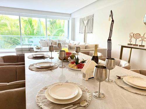a living room with a table with plates and wine glasses at Bolongo 3BR your exclusive oceanfront escape in Punta Mita