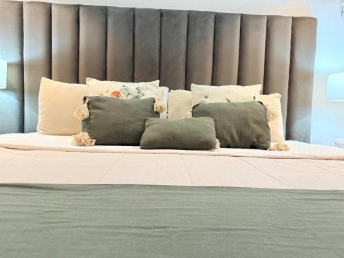 a bed with a bunch of pillows on it at Bolongo 3BR your exclusive oceanfront escape in Punta Mita