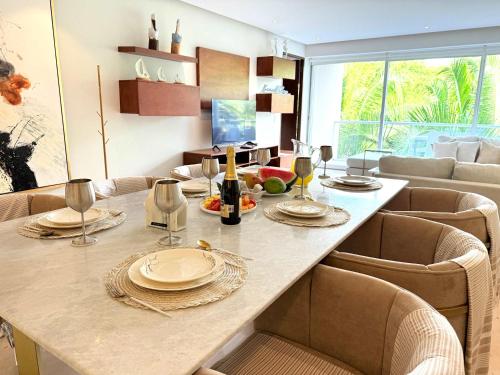 a dining room with a table with chairs and a couch at Bolongo 3BR your exclusive oceanfront escape in Punta Mita