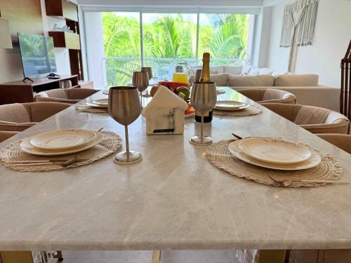 a table with glasses and a bottle of wine on it at Bolongo 3BR your exclusive oceanfront escape in Punta Mita