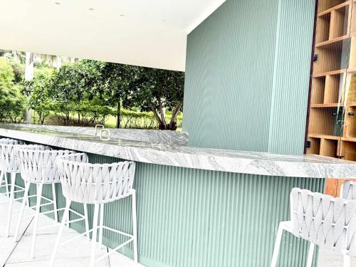 a bar with white chairs and a blue wall at Bolongo 3BR your exclusive oceanfront escape in Punta Mita