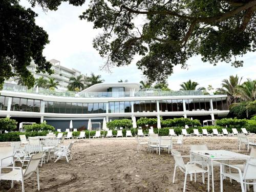 a group of tables and chairs in front of a building at Bolongo 3BR your exclusive oceanfront escape in Punta Mita