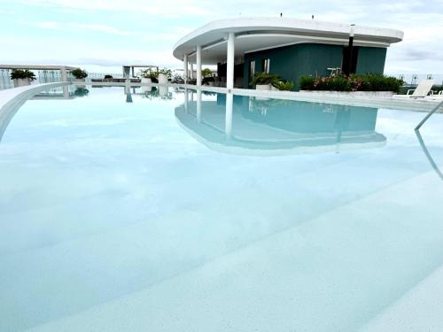 a pool of water with a building in the background at Bolongo 3BR your exclusive oceanfront escape in Punta Mita