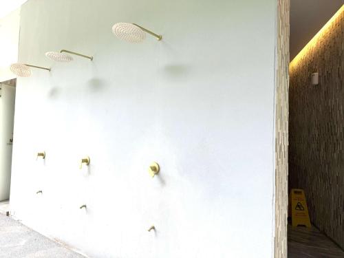 a white wall with four metal hooks on it at Bolongo 3BR your exclusive oceanfront escape in Punta Mita