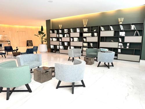 a living room with chairs and shelves of books at Bolongo 3BR your exclusive oceanfront escape in Punta Mita