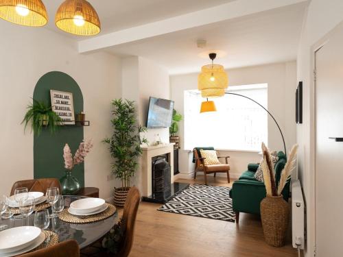 a living room with a table and a fireplace at Amica Rose in Belfast
