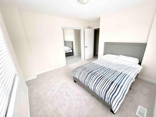 a bedroom with a bed with a black and white striped blanket at New 3 Bedroom 2 Bathroom Home in West Niagara in Thorold