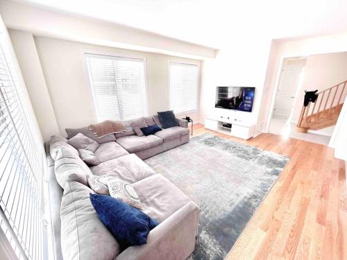 a living room with a couch and a television at New 3 Bedroom 2 Bathroom Home in West Niagara in Thorold