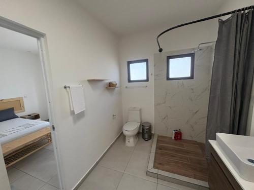 a white bathroom with a toilet and a sink at Linda casa in Kulkana Cancun in Cancún