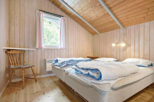 ein Schlafzimmer mit einem Bett in einem Zimmer mit einem Fenster in der Unterkunft 1412 Aakirkeby - Boesparken 12 in Vester Sømarken