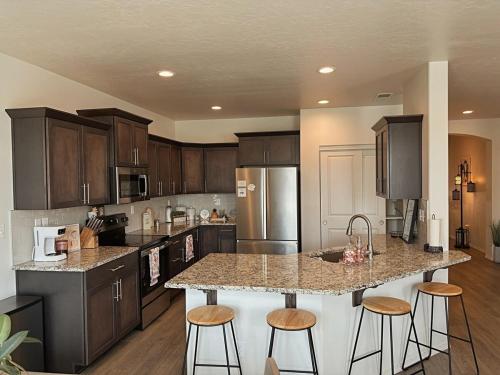 コールドウェルにあるIdaho Modern Retreat King Bed Backyard 2BR2BAのキッチン(木製キャビネット付)、島(バースツール付)