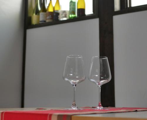 two wine glasses sitting on top of a table at Vacation House YORAKURA よら蔵 in Komoro
