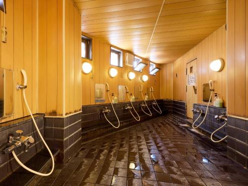 a bathroom with a row of hoses in a room at Hotel Wakamizu in Chino