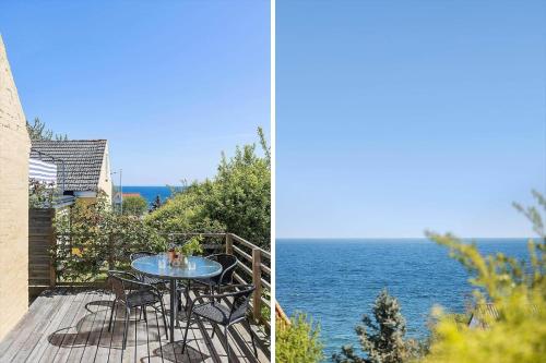 a table and chairs on a deck with a view of the ocean at 6821-Allinge-Laerkevaenget-7-B in Allinge