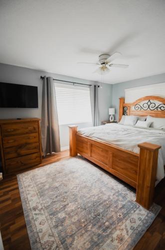 a bedroom with a large wooden bed and a television at Bright and Peaceful Apt in Midvale in Midvale