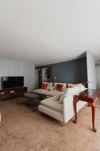a living room with two white couches and a flat screen tv at Bright and Peaceful Apt in Midvale in Midvale