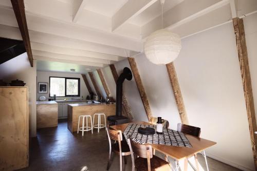 a dining room and kitchen with a table and chairs at Cape Schanck A-Frame House in Cape Schanck