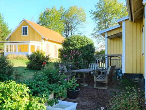 a backyard with a table and chairs and a house at Pleasant holiday home for 8 guests in Vimmerby
